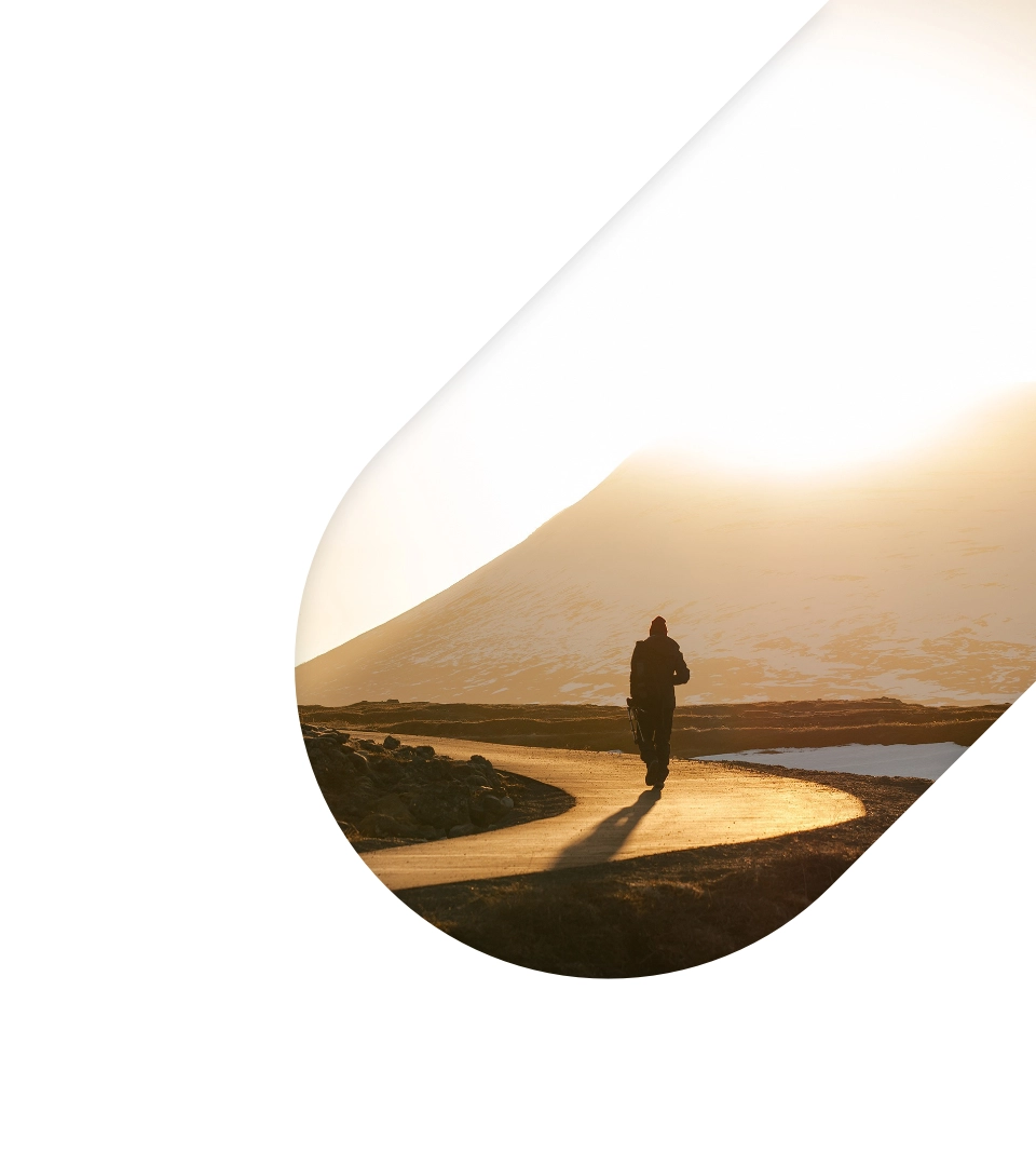 A person walking a path toward a mountain.